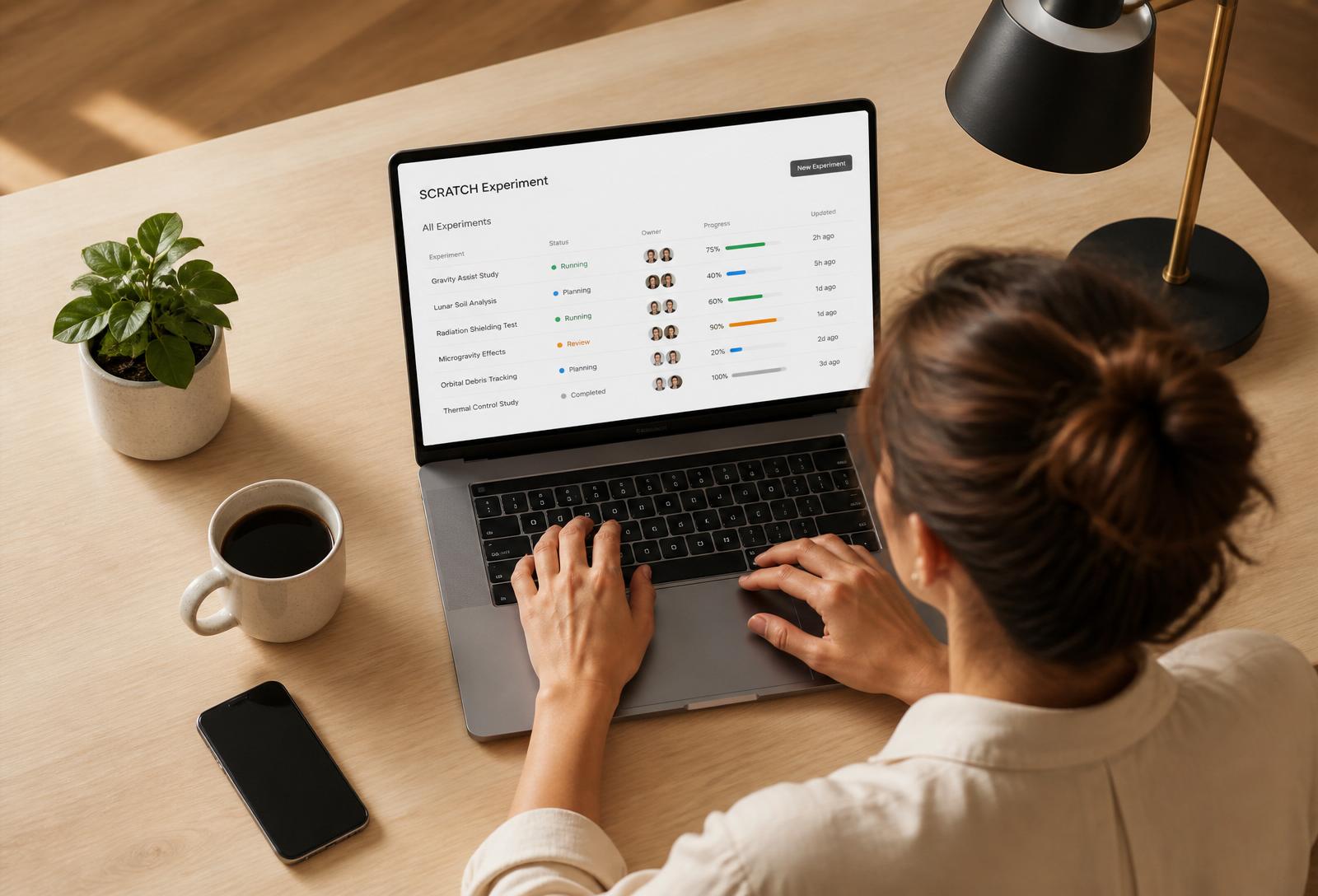 Overhead view of a female entrepreneur reviewing a lean startup experiment dashboard on her laptop